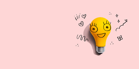 Yellow light bulb with happy face - flat lay