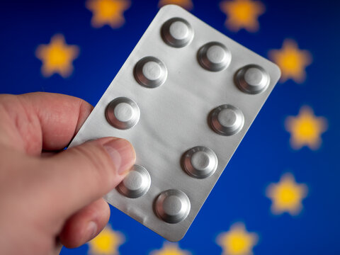 Silver Pill Package in Hand Before European Union Flag