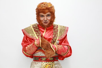 A young Asian man  dressed as a monkey king participates in the Chinese New Year parade, Chinese culture