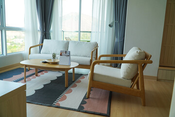 Interior of light living room with white sofas, coffee table and large window