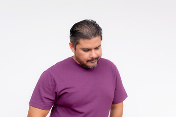 Portrait of a disgraced middle aged man in a purple shirt sulking, looking depressed. Studio shot on a white background.