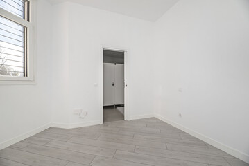 An empty room in a ground floor home with gray parquet floors