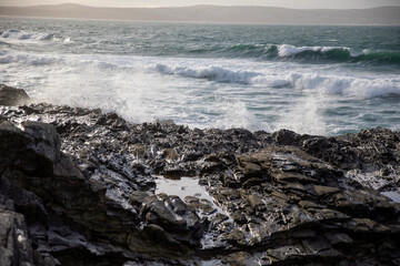 Waves crashing on the rocky shore at Godrevy Beach in the UK.
