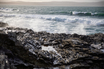 Waves crashing on the rocky shore at Godrevy Beach in the UK.