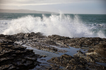 Waves crashing on the rocky shore at Godrevy Beach in the UK.