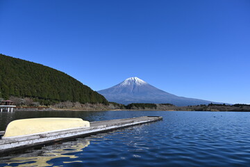 静岡県の朝霧高原に田貫湖の桟橋に置いてある船と冬景色の富士山の眺め