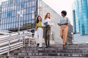 Confident businesspersons talking in front of modern office building. Businesswoman have business...