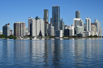 Fototapeta na wymiar City of Miami, Florida skyline reflected in calm water of Biscayne Bay on calm cloudless December morning.