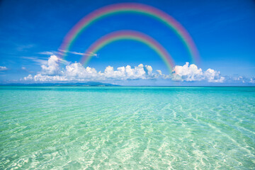 沖縄の美しいサンゴ礁の海にかかる虹
