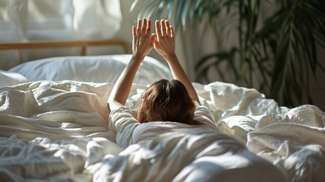 Woman stretching hands in bed after wake up in the morning, Concept of a new day and joyful weekend