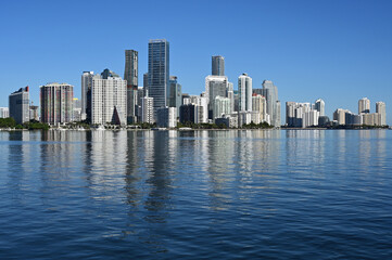 Fototapeta premium City of Miami, Florida skyline reflected in calm water of Biscayne Bay on calm cloudless December morning.