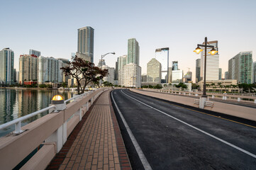 Brickell Key Bridge and City of Miami skyline at sunrise under clear blue sky on tranquil December morning.