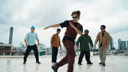 Professional break dance team practice B-boy dance while multicultural friends at rooftop. Young modern dancing group doing hip hop movement. Style,fashion,action. Outdoor sport 2024. Endeavor. - obrazy, fototapety, plakaty