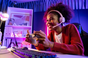 African American girl streamer playing online fighting with Esport skilled team wearing headphones...