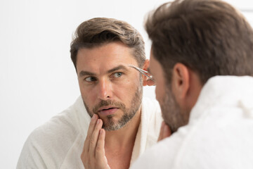 naked man with scissors trimming his beard in the bathroom. Bearded man, bearded male. Barber scissors, barber shop. Vintage barbershop,man trimming his beard.