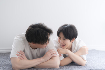 うつ伏せになりながら寝転がる仲良しの見つ目合うカップル(恋人や結婚）のイメージ 　クローズアップ