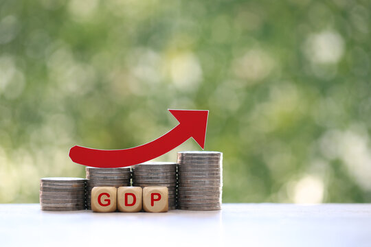 Red arrow on coins money and gpd word on natural green background, GDP (Gross Domestic Product) concept