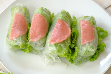 Spring rolls are a rolled appetizer or dim sum commonly found in Chinese and Asian cuisine. Raw fresh vegetable salad roll with mayonnaise.