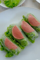 Spring rolls are a rolled appetizer or dim sum commonly found in Chinese and Asian cuisine. Raw fresh vegetable salad roll with mayonnaise.