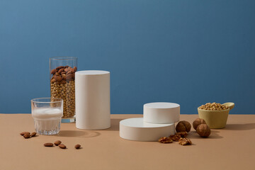 Minimal scene with geometric shaped podiums displayed with a cup of milk, a bowl of soybeans,...