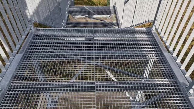 industrial hall, warehouse has a steep staircase with high resistance even under heavy load galvanized steel floor grate and railings. expanded metal, edges of stairs of safety, black, perforated