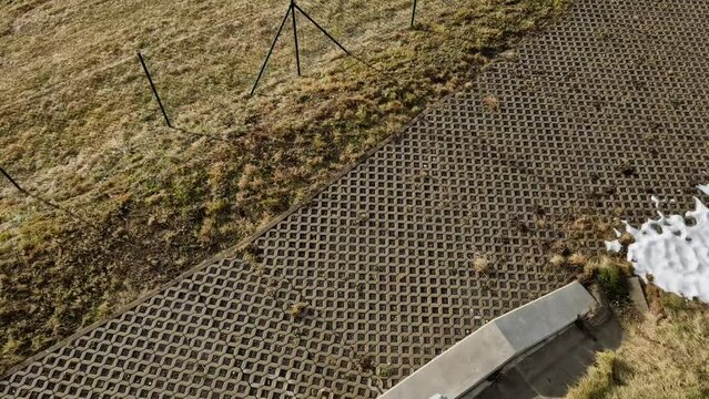 new established street in the city, the longitudinal parking lot is made of gray concrete infiltrating tiles with crevices filled with gravel. measures to limit  outflow of water from road, wire mesh