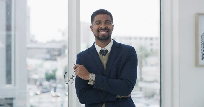 Smile, crossed arms and face of businessman in the office with glasses for vision in a classy suit. Happy, portrait and young male lawyer with positive, good and confident attitude in workplace.