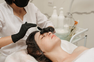 close-up of a woman's cosmetologist's hands massaging the client's facial skin. The concept of a cosmetic procedure.