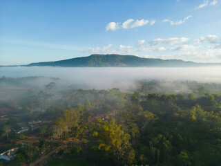 Aerial view  of flowing fog waves on mountain tropical rainforest.