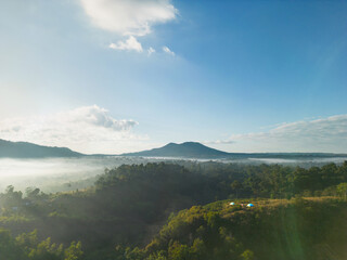 Aerial view  of flowing fog waves on mountain tropical rainforest.