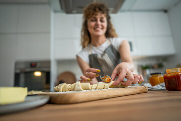 Obraz na płótnie Canvas Woman caucasian female prepare breakfast croissants dough at kitchen