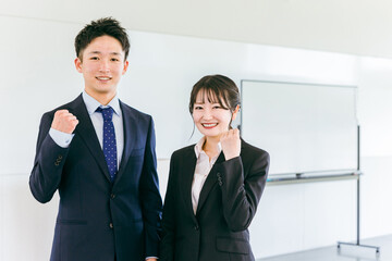会議室・オフィスにいる若い日本人ビジネスマンとビジネスウーマン
