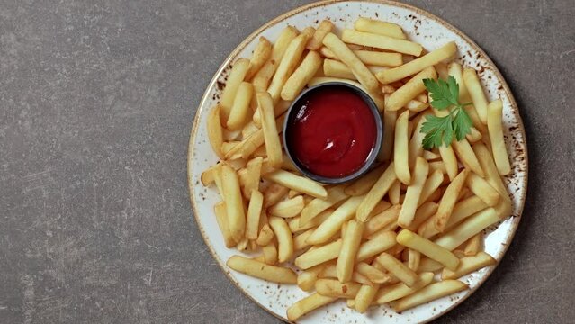 French fries, tomato ketchup on a plate, top view