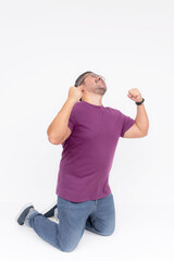 A man, feeling exhilarated, sliding on his knees and pumping his fists. Celebrating victory,...