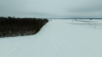 Drone photography or rural farmland covered by snow and ice during cloudy winter day