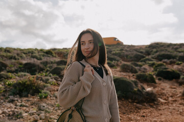 Naklejka premium Beautiful caucasian woman traveling with backpack in mountains. Brown hair female wears beige sweater spend time outdoor. Concept weekend, lifestyle.