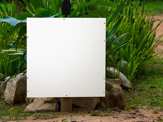 Pancarte blanche pour maquette dans un environnement végétal et tropical