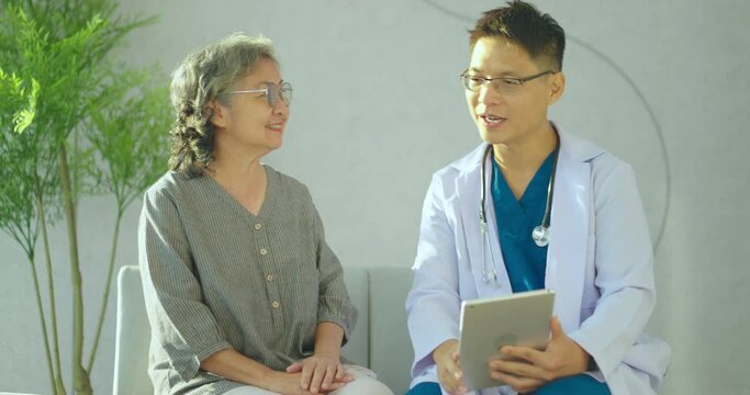Senior woman talking with male doctor at hospital. Doctor makes an appointment with a senior woman at the hospital.	