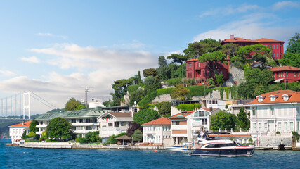 Fototapeta na wymiar View from Bosphorus strait of the green mountains of the Asian side, with traditional houses and dense trees with Bosphorus Bridge in the far end in a summer day, Istanbul, Turkey