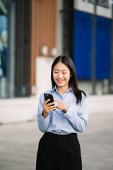 Fototapeta premium Young Asian business woman leader entrepreneur, professional manager holding digital tablet computer uon the street in big city