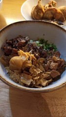 Rice noodle with pork and dumpling on wooden table