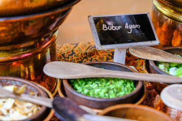 Many type of condiments and topping served on top of the table with batik pattern as background. Indonesian Food served in restaurant, hotel, travel and culinary concept.