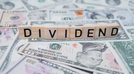 The inscription dividend on the background of American dollars. Investing in Dividend Aristocrats