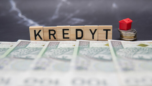 The inscription Kredyt next to Polish banknotes and a red house. Mortgage loan for the purchase of your first apartment. Real estate market in Poland