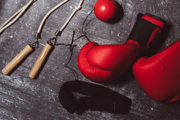 Boxing equipment in a flat lay photo. Boxing gloves, next to a skipping rope and a reflex ball on a...