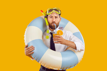 Portrait of a funny bearded man in scuba glasses drinking orange juice cocktail holding inflatable...