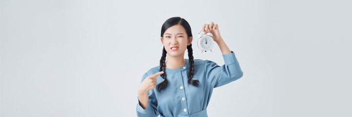Angry young Asian woman point to a clock on white background