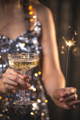 The girls pour champagne into round glasses. Women in a sparkling dress. Full cocktail creamers - le coupe