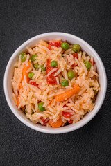 Delicious boiled rice with vegetables peppers, green peas, salt, spices and herbs