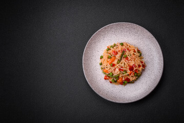 Delicious boiled rice with vegetables peppers, green peas, salt, spices and herbs